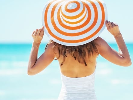 Sunbathing woman at beach in hat